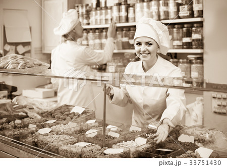 women with hats selling nuts and pastry in shop 33751430