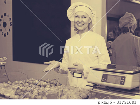 Happy woman posing in bakery with baguettes Happy woman posing in bakery with baguettes 33751683