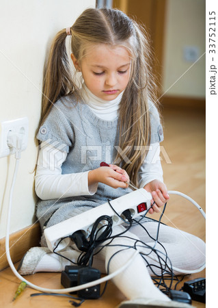 Small girl playing with charging units and smiling 33752115