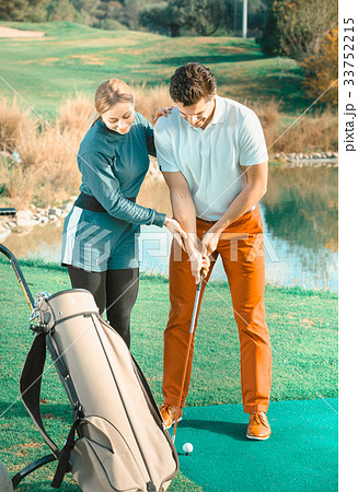 Positive trainer showing player how to hit ball Positive trainer showing player how to hit ball 33752215