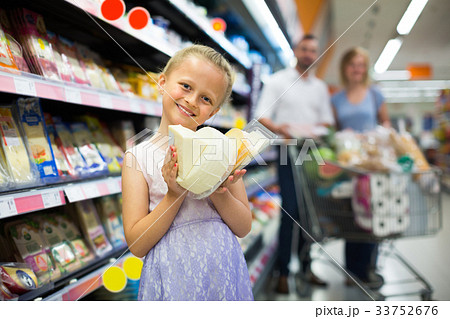 Girl holding cheese in hands in supermarket. 33752676
