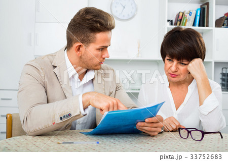 Man discusses correctness of paperwork with fellow worker Man discusses correctness of paperwork with fellow worker 33752683