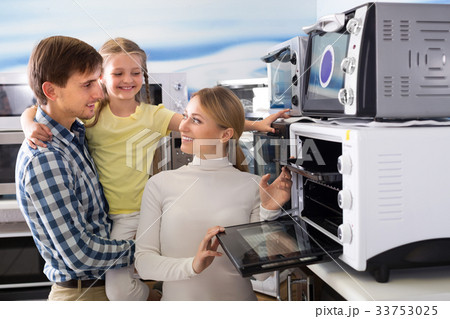 Portrait of happy family selecting microwave Portrait of happy family selecting microwave 33753025