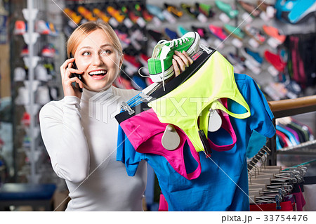 Girl picking a sport bra while talking to the phone 33754476