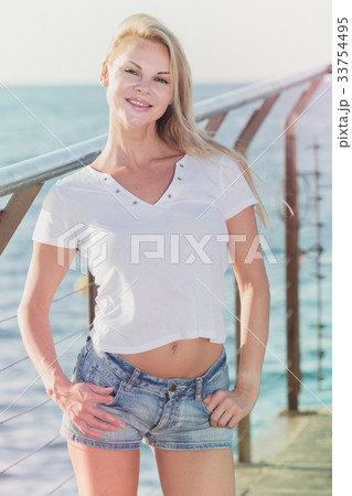 Cheerful female is posing playfully on pirce in her free time Cheerful female is posing playfully on pirce in her free time 33754495