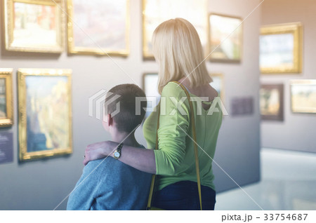 Mother and son looking at paintings in halls of museum 33754687