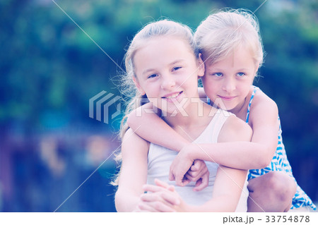 Two small happy sisters outdoors Two small happy sisters outdoors 33754878