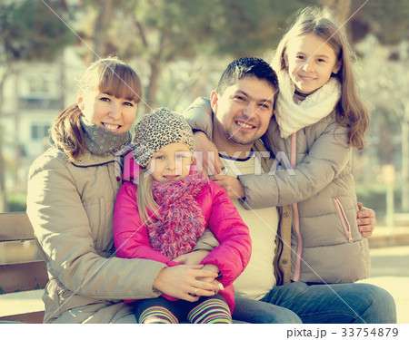 family with two girls outdoors in sunny fall day family with two girls outdoors in sunny fall day 33754879