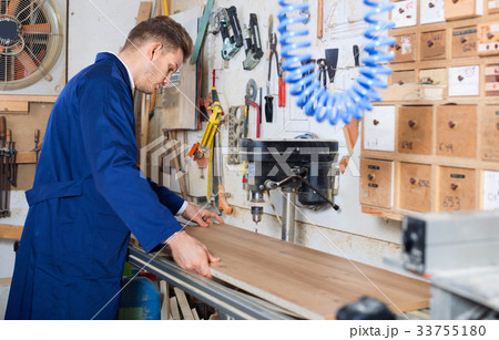 Young guy using machine to process plank 33755180