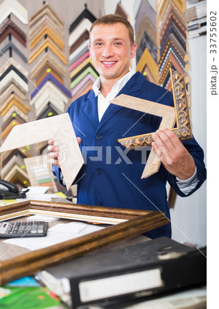 attentive man seller in picture framing studio with wooden details attentive man seller in picture framing studio with wooden details 33755602