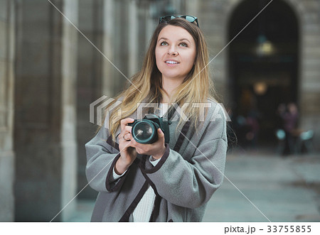 Girl holding camera and photographing Girl holding camera and photographing 33755855
