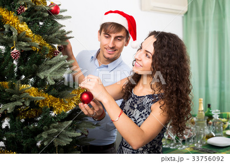 Couple decorating Christmas tree 33756092