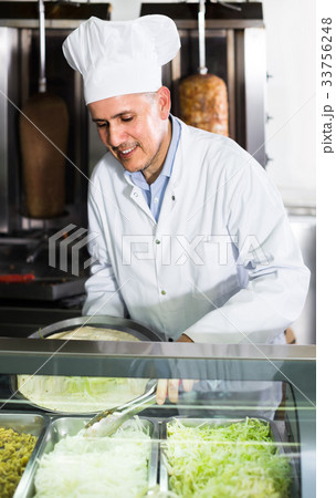 man cook making kebab dish on kitchen in fast food restaurant man cook making kebab dish on kitchen in fast food restaurant 33756248