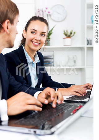 Man and woman coworkers working on computers Man and woman coworkers working on computers 33757115