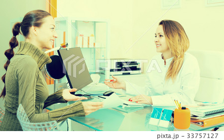 Smiling woman visitor consulting woman beautician Smiling woman visitor consulting woman beautician 33757127