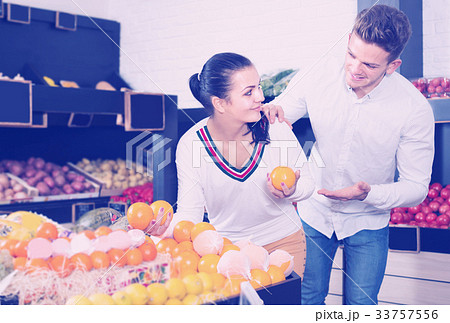 Buyers examining various fruits in grocery store Buyers examining various fruits in grocery store 33757556