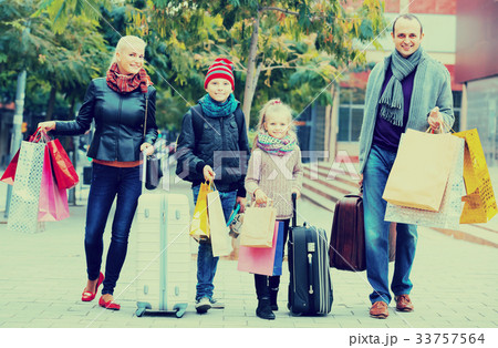 Parents with children shopping in city. 33757564