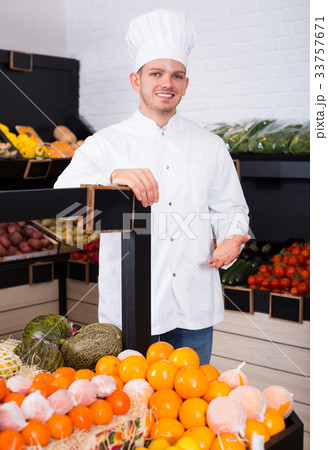 Smiling male chef looking for fresh fruits Smiling male chef looking for fresh fruits 33757671