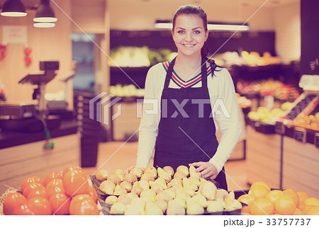 Assistant displaying fruits of grocery store 33757737