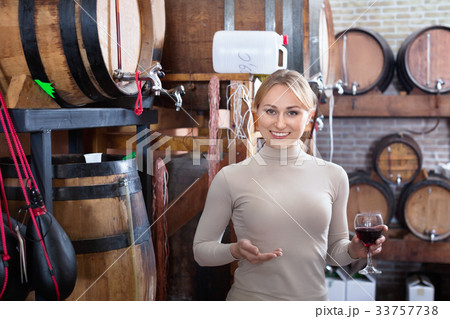 Portrait of female holding wine glass in winery 33757738