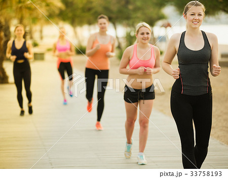 Women running along embankment in sunny morning 33758193
