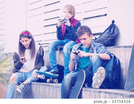 Three teenagers with smartphones Three teenagers with smartphones 33758326