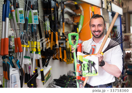 Man selecting gardening equipment in store. Man selecting gardening equipment in store. 33758360