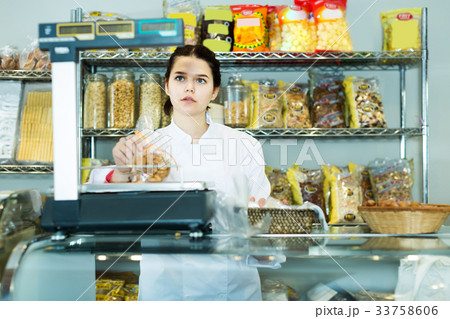Woman checks the weight of a package of cookies 33758606