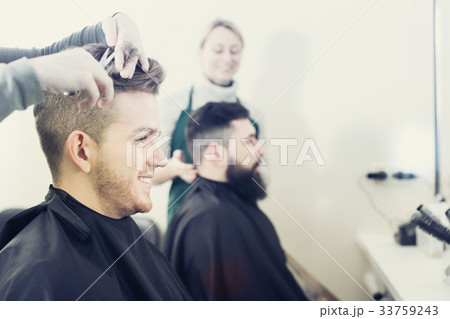 Clients having their hair cut by hairdressers 33759243