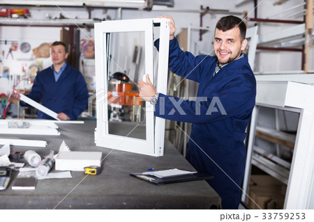 Cheerful labour demonstrating PVC profiles 33759253