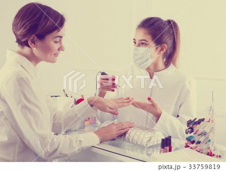 Woman doing shellac manicure Woman doing shellac manicure 33759819