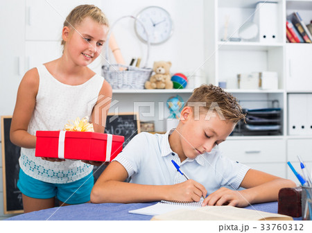 Girl is giveing a gift to friend on his birthday Girl is giveing a gift to friend on his birthday 33760312