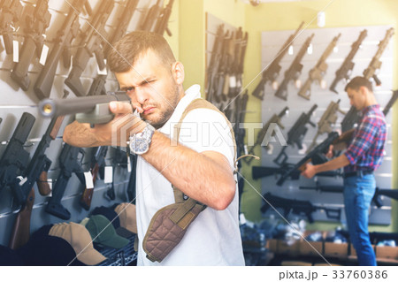 Portrait of male which is choosing air-powered gun 33760386
