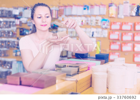 Smiling woman is choosing small boxes for gifts 33760692