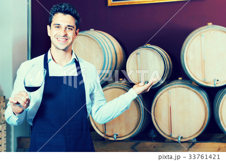 Man having glass with wine sample in alcohol section 33761421