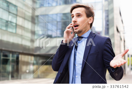 Businessman talking about work on the mobile phone at the street 33761542