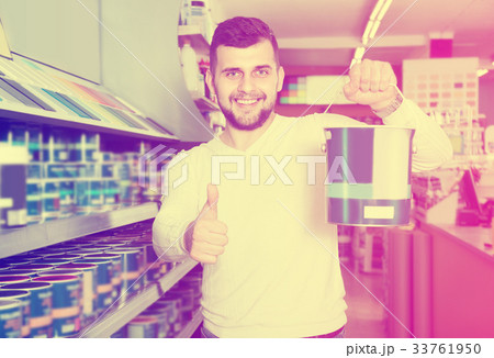 Adult man is deciding on best wall paint 33761950