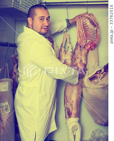 Butcher cutting fresh lamb meat 33762018