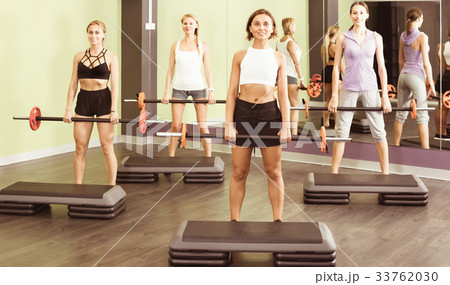 Portrait of sporty women exercising with barbell in fitness club 33762030