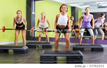 Portrait of sporty women exercising with barbell in fitness club 33762031