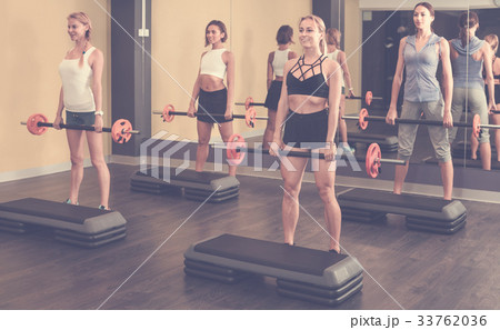 Portrait of sporty women exercising with barbell in fitness club 33762036