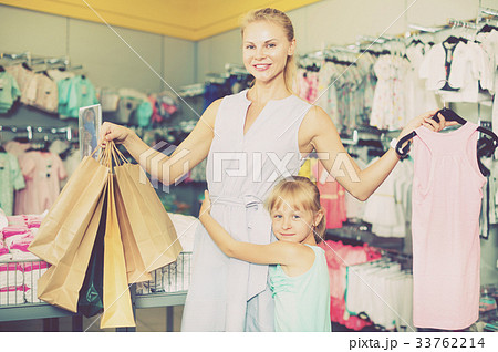 Mother with daughter holding packages with purchases Mother with daughter holding packages with purchases 33762214