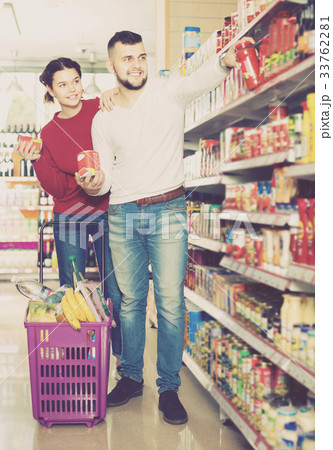 Happy family couple buying tinned food 33762281