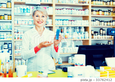 Mature female seller suggesting useful skin care products 33762412
