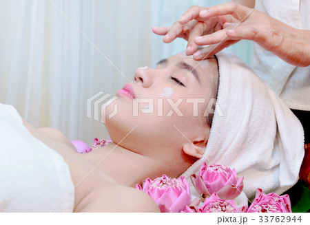 woman receiving clay facial mask in spa salon 33762944