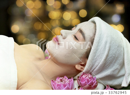 woman receiving clay facial mask in spa salon 33762945