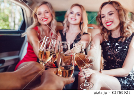 Pretty women having party in a limousine car and 33769925