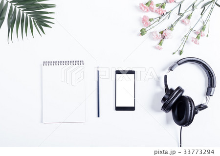 Headphones, smart phone, a paper notebook Headphones, smart phone, a paper notebook 33773294