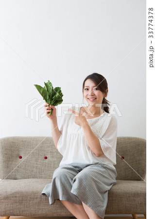 ほうれん草を持つ妊婦さん 33774378