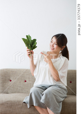 ほうれん草を持つ妊婦さん 33774379